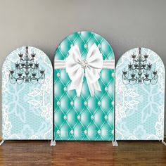 three blue and white wall panels with a chandelier on one side and a bow on the other