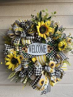 a yellow and black welcome wreath with sunflowers