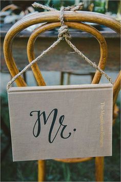 a wooden chair with a sign hanging from it's back that says mr and mrs