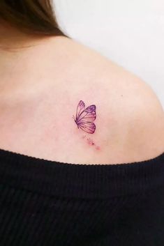 a woman's back shoulder with a small butterfly tattoo on the left side of her upper arm