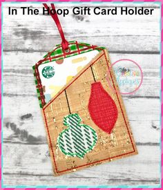 an ornament hanging from the side of a wooden wall with text that reads in the drop gift card holder