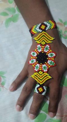 a person's hand with beaded bracelets on it