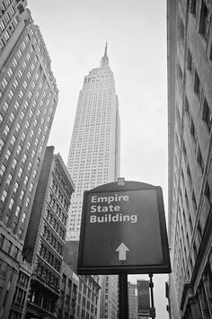 empire state building in new york city with an arrow pointing to the right and another sign that says empire state building