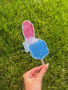 a hand holding a popsicle with the shape of an american flag painted on it