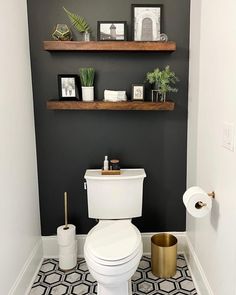 a white toilet sitting in a bathroom next to a shelf filled with pictures and plants