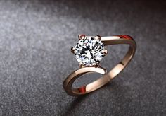 a ring with a diamond on it sitting on a table