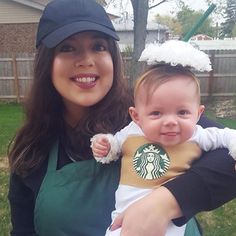 a woman holding a baby in her arms wearing starbucks t - shirt and baseball cap