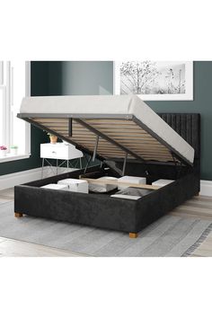 the bed frame is made up and ready to be used as a storage compartment for an ottoman