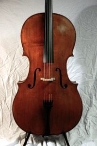 an old violin sitting on top of a stand in front of a white sheet covered wall