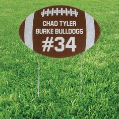 a brown and white football shaped yard staker with the number 34 written on it