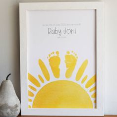 a white frame with a yellow hand and foot print on it next to a pear