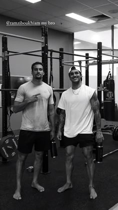 two men standing next to each other in a gym with punching gloves on their hands