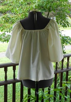 "Made to order This shirt is made from 100% cotton. It has elastic at the neckline and 3/4 length sleeves. Can be worn on or off the shoulder. The 3/4 length sleeve on this shirt makes it cooler for summer festival and faire wear! Available in Bleached White Muslin or Natural Muslin. (Also available different colors of 100% cotton and in a poly cotton blend - message me if you have a color request ). These are all good quality lightweight shirting fabrics. This is a loose fit shirt. Sized to fit Wench Costume, Shirting Fabric, Loose Fit Shirts, Pirate Costume, Peasant Blouse, Women's Costumes, Summer Festival, Halloween Ideas, Off Shoulder Blouse