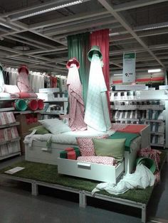 an assortment of bedding in a store with lots of boxes on the floor and shelves