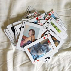 playing cards with pictures of cats and dogs are laid out on a bed sheet in front of the camera