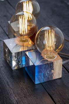 three glass lamps sitting on top of a wooden table