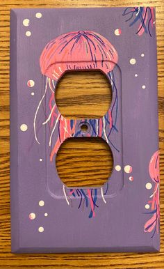 a purple light switch cover with jellyfish on it