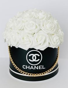 a black and white hat with flowers on it's top is adorned with a gold chain