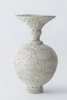 a white vase sitting on top of a table