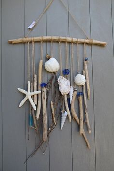 a wind chime made out of driftwood and seashells on the side of a building