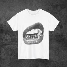 A y2k grillz tee with big lips design, this unisex T-shirt is made from 100% ring-spun cotton, offering a lightweight feel perfect for year-round wear. The classic fit and crew neckline provide a versatile style suitable for any occasion. This tee comes in 2 color ways and is perfect's for y2k/streetwear style. For any suggestions, questions, comments, or concerns always feel free to contact me anytime. Product features - Shoulder tape for stability - Tubular knit construction without side seams - Elastic ribbed knit collar - Made from strong and smooth fabric - Classic fit and tear-away label for comfort Care instructions - Machine wash: warm (max 40C or 105F) - Non-chlorine: bleach as needed - Tumble dry: medium - Do not iron - Do not dryclean Discover the convenience of Express 2-day de Lips Design, Color Ways, Lip Designs, Streetwear Style, Style Streetwear, Y2k Streetwear, Versatile Style, Crew Neckline, Streetwear Fashion