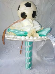 a cake shaped like a soccer ball on top of a table with flowers and ribbons