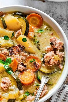 a white bowl filled with meat and vegetable soup