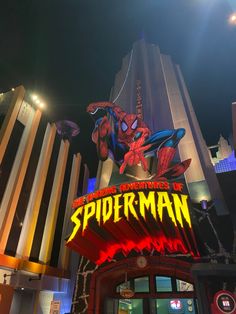 the entrance to spider - man is lit up at night