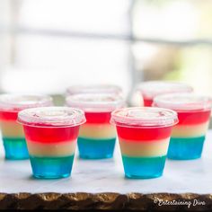 small cups filled with red, white and blue jello sitting on top of a table