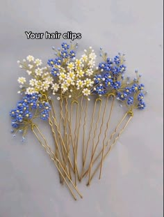 blue and white flowers are arranged on gold bobby pins