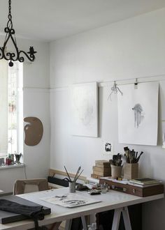 an art studio with paintings and drawings on the wall