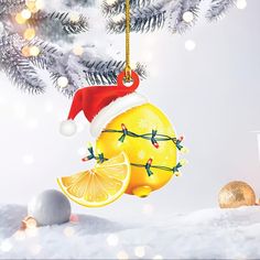 an ornament hanging from a christmas tree decorated with lemon slices and santa's hat