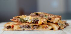 three quesadillas stacked on top of each other with cheese and meat in them