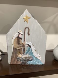 a nativity scene is displayed on a wooden house with a gold star above it