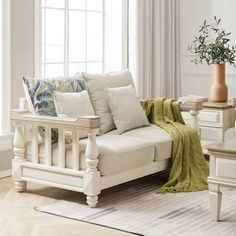 a living room scene with focus on the couch and chair, coffee table and potted plant