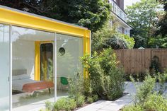 a yellow and white house in the middle of a garden