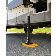 the front end of a truck with a yellow stand on it's side and grass in the background