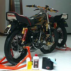 the motorcycle is being worked on by an expert in painting it black and gold,