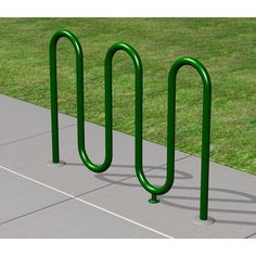 three green bike racks sitting next to each other on top of a cement sidewalk in front of grass