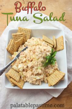 a white plate topped with tuna salad and crackers