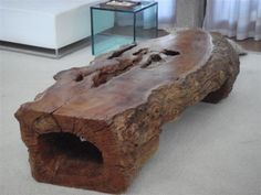 a large piece of wood sitting on top of a white floor next to a glass table