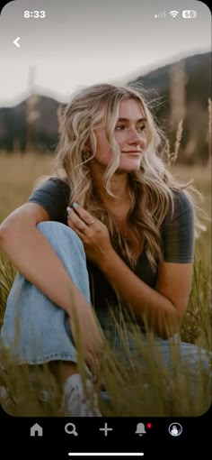 a woman sitting in the grass with her hand on her chest