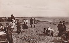 an old black and white photo of people on the beach