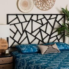 a bed with blue sheets and pillows next to a wall mounted wicker basket on the wall