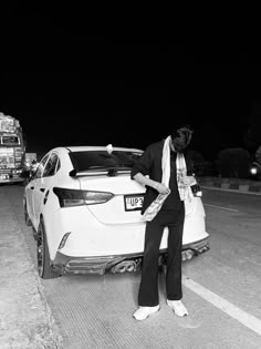 a man standing next to a white car