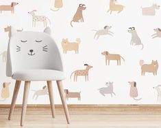 a white chair sitting in front of a wall with cats and dogs on it