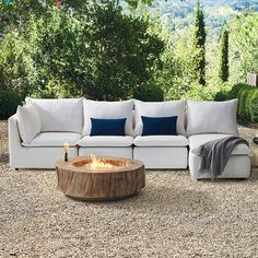 a white couch sitting next to a fire pit