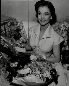 a woman sitting on a couch with flowers in her lap