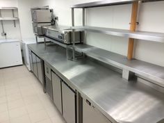 an industrial kitchen with stainless steel counters and refrigerators