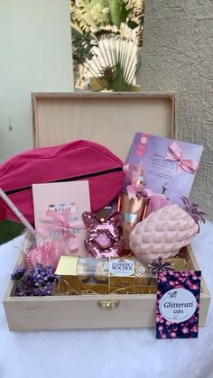 an open suitcase filled with pink items on top of a white tablecloth covered table